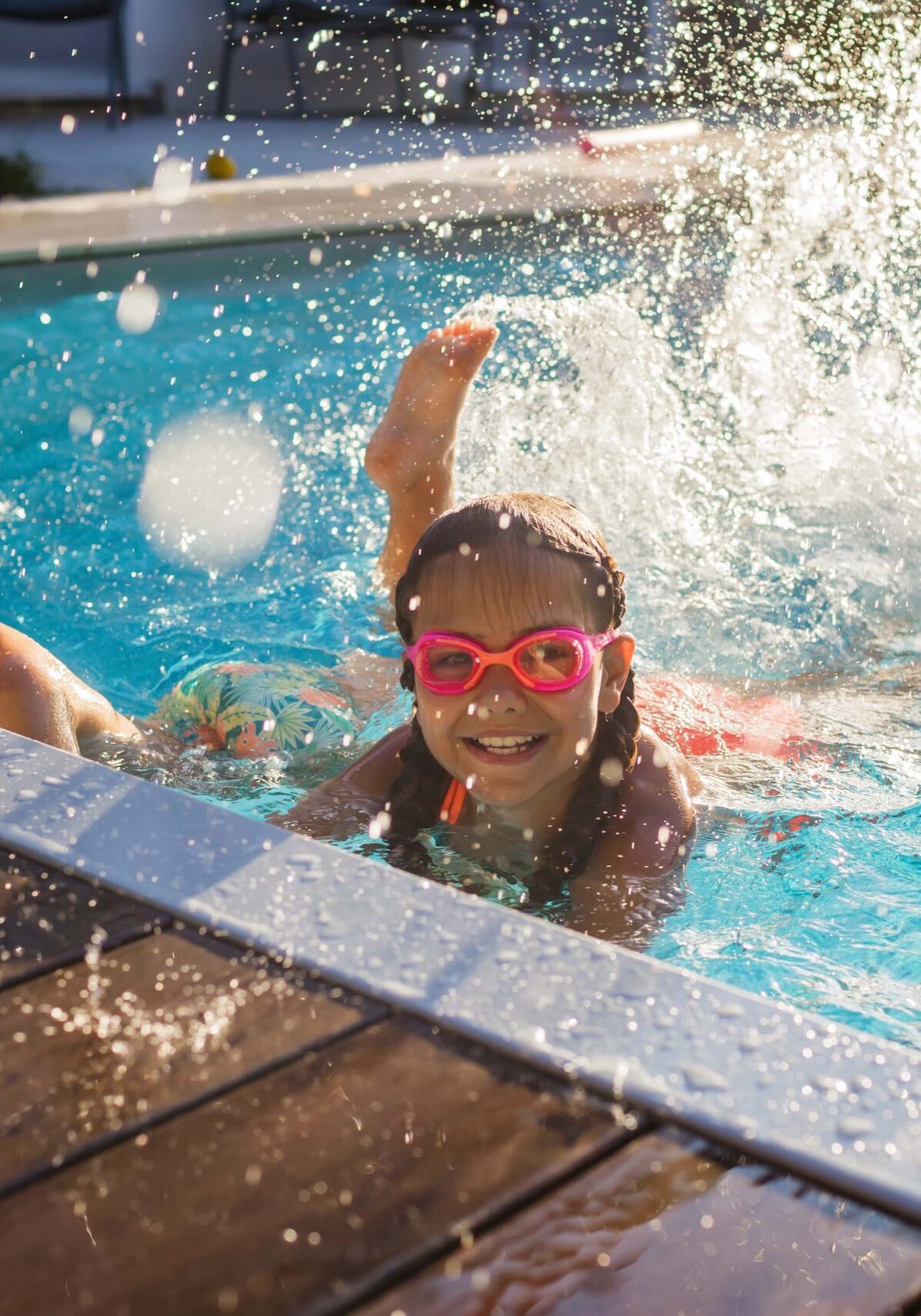 Cheerful children in googles laughing while playing in swimming pool at sunny day, refreshing at heat weather, active vacation and healthy lifestyle, happy summertime